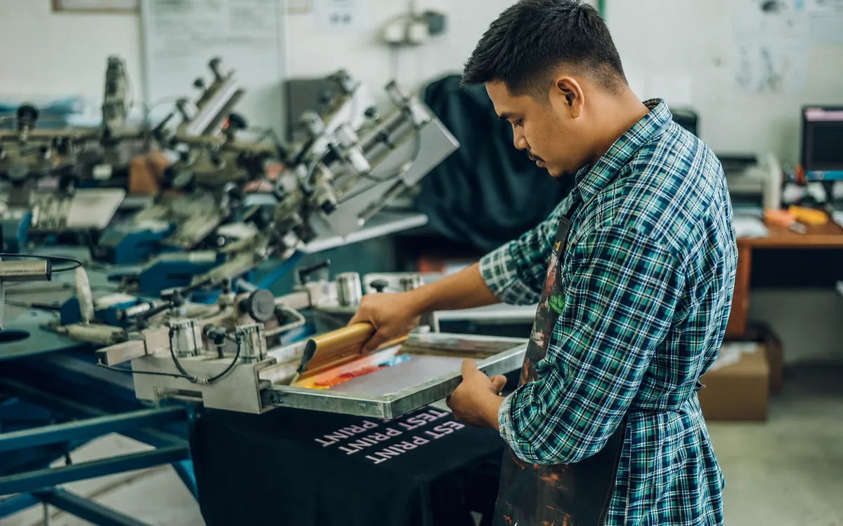 Proses cetakan silkscreen pada baju seragam di Shah Alam, Selangor